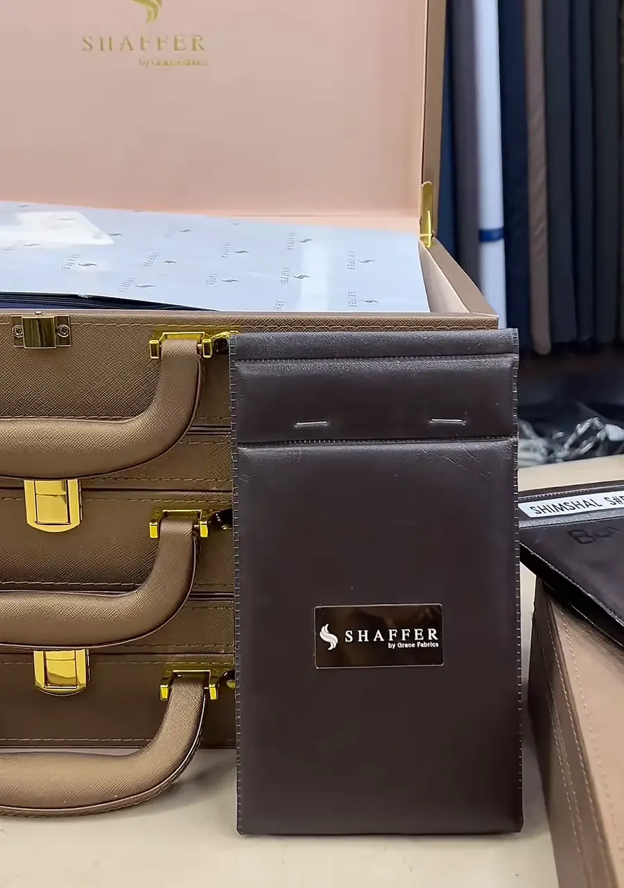 A Shaffer fabric box beside stacked brown presentation cases on the counter
